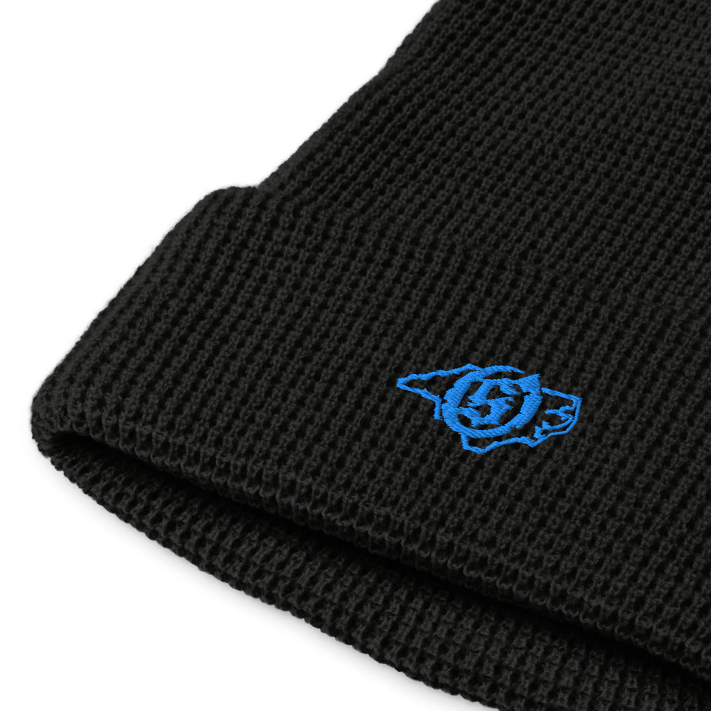 Sail On NC waffle beanie in Black with blue thread embroidered logo, close-up view