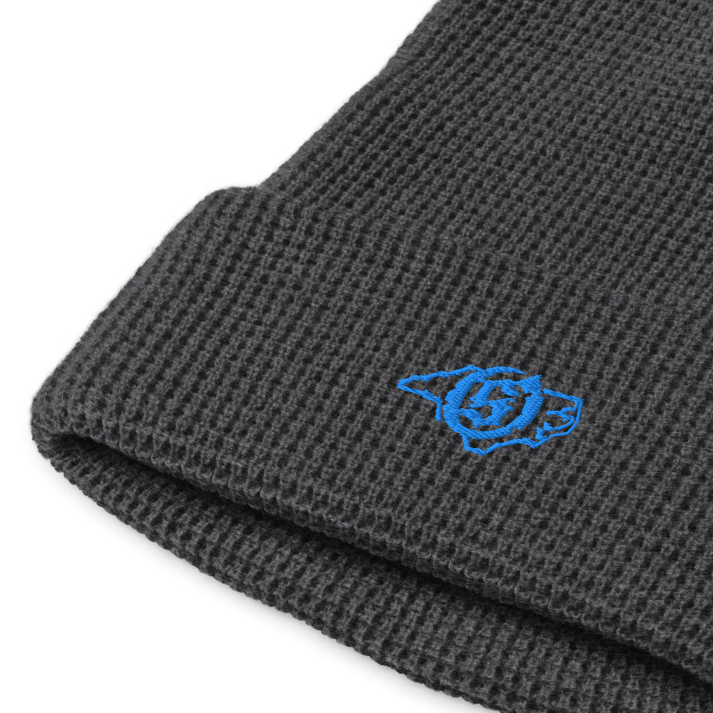 Sail On NC waffle beanie in Heather Charcoal with blue thread embroidered logo, close-up view